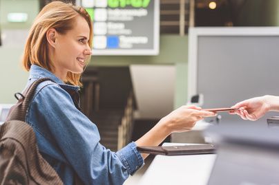 Passenger handing documents at an airport counter